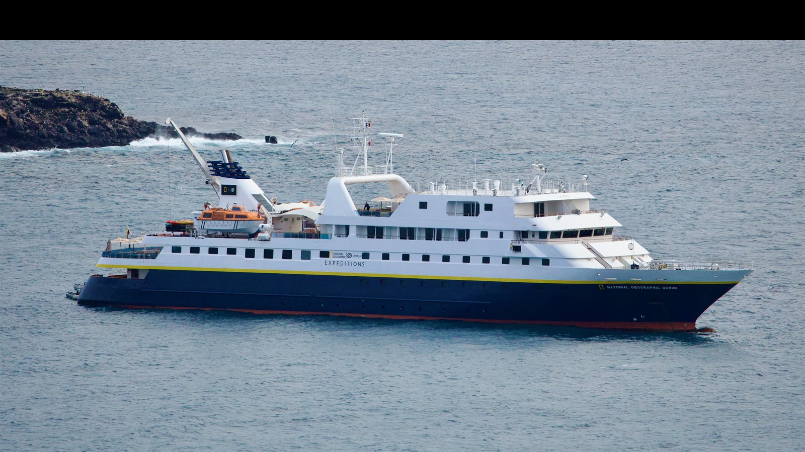 Foto do National Geographic Gemini fundeado nas Galápagos, com o casco e a superestrutura vistos em primeiro plano.