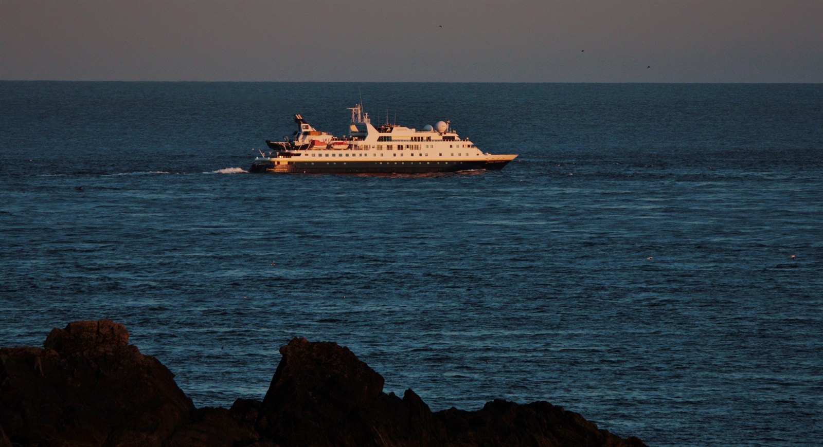 Foto do navio National Geographic Orion contornando Sumburgh Head, nas ilhas Shetland, em mar aberto.